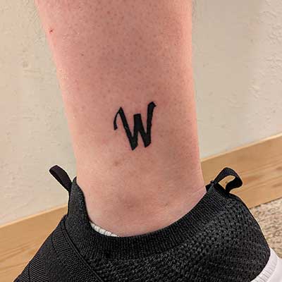 The Waseca Ink icon tattooed near an ankle.