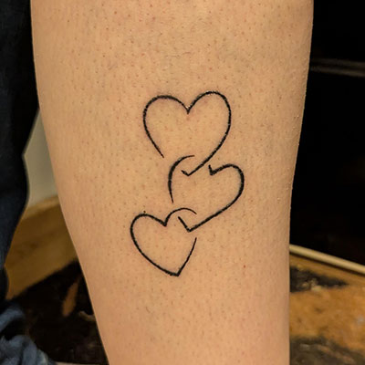 Interlinked hearts tattoo on a leg