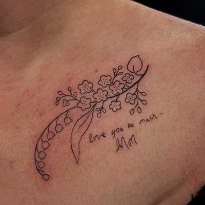 Flowers and handwriting tattoo on a collarbone